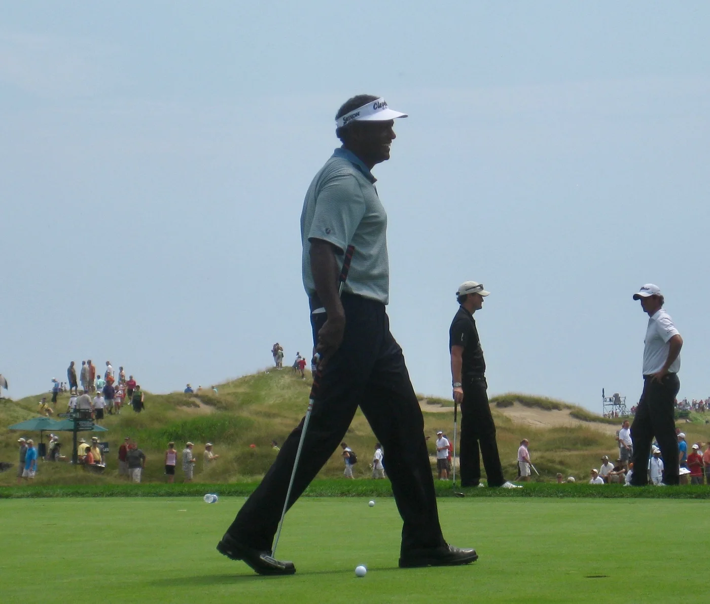 Vijay Singh 戴著白色遮陽帽走在球場上